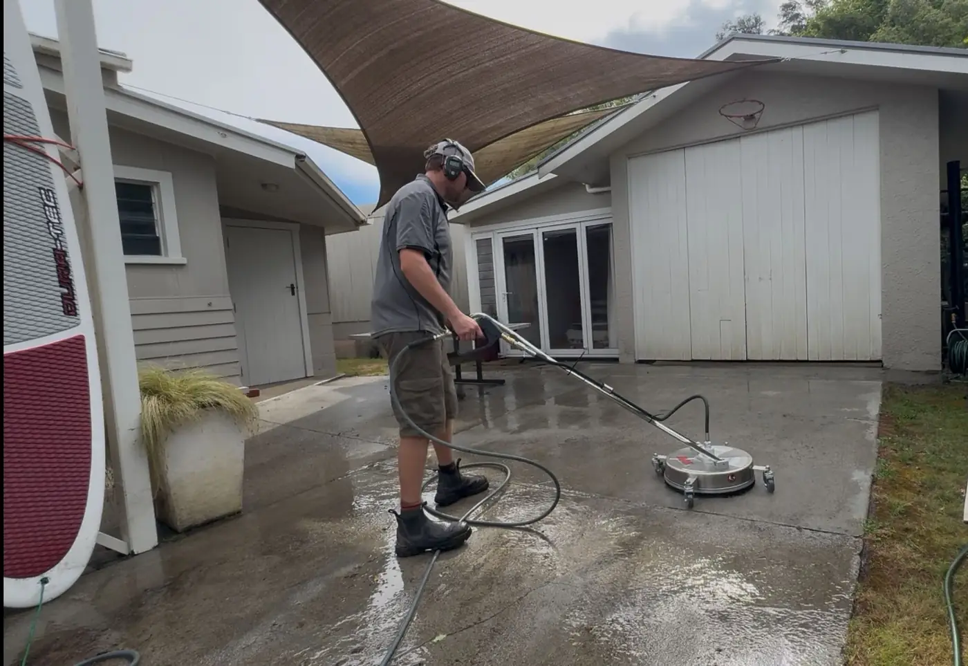 Eric water blasting a concrete patio in Nelson with a rotary surface cleaner
