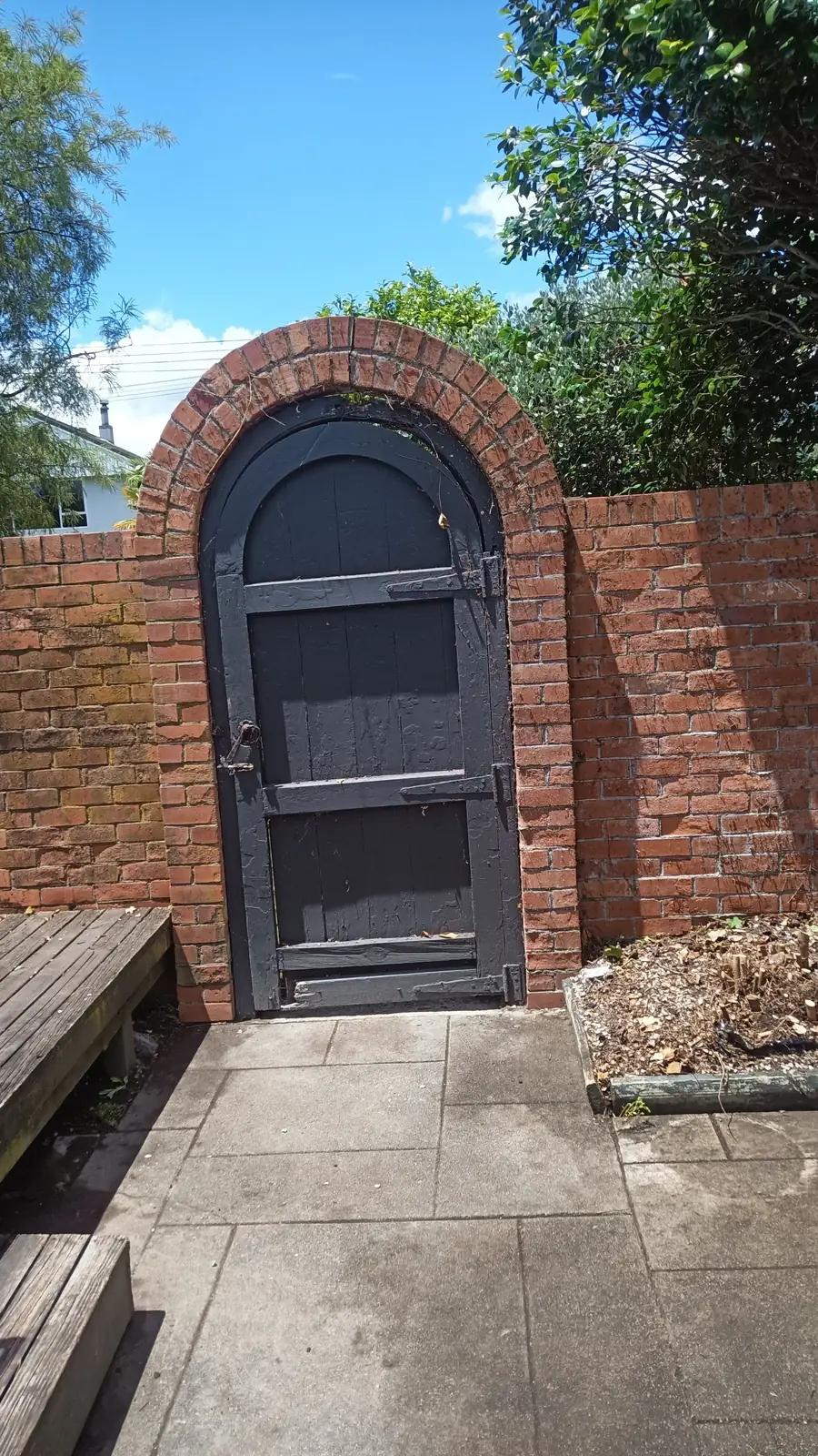 An old brick garden wall and gate after cleaning